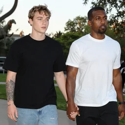 pete davidson and kanye west holding hands at a sunset zoo park