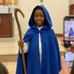 black boy dressed as shepherd for a church nativity play, blue hooded cloak, shepherd's crook, candid, cell phone photo, indoors, mm, iso, trending
