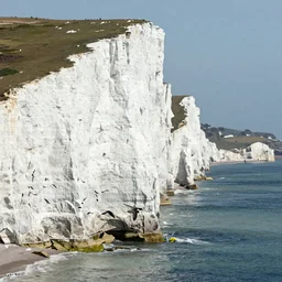 extremely detailed 4k HDR national geographic photograph of incredibly high white cliffs with exotic sea birds diving off of them into the sea fishing