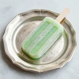 a green smooth popsicle served on a luxurious silver platter