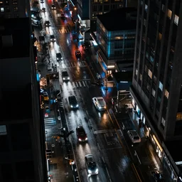 a city street at night, raining, photograph, cars on the road, cyberpunk, sharp focus, intricate detail, drone shot