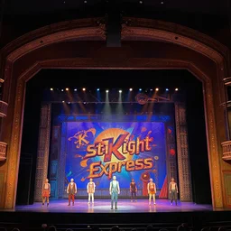 photo of a huge theaterstage, play is starlight express, 3 actors on stage, 8 k, multicolored, exaggerated detailed, long shot