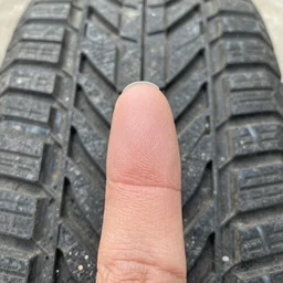 closeup of fingertip with embossed tire tracks, stock photo