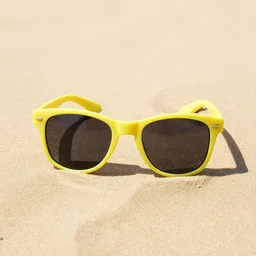 A lemon wearing sunglasses on the beach sand