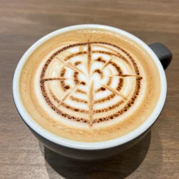 most attractive cup of flat white coffee ever, with a maze drawn in the foam