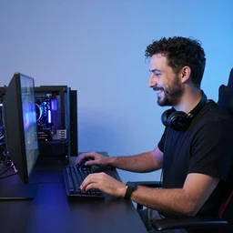 a man smiling while his gaming setup is dissolving n-4 i-