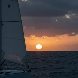 sun setting over stormy sea, photo realistic, hyperreal, bough of sailboat in foreground