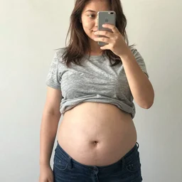 a full - body selfie of sommer ray with an extremely round and distended chubby belly, focus on facial - details!!!!!!, focus on her belly fat pressing against her clothes, focus on the immense size of her belly, instagram post, 8 k resolution