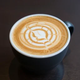 most attractive cup of flat white coffee ever, with a labyrinth drawn in the foam