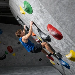 “climbing in an indoor bouldering gym, high definition, highly realistic”