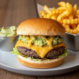 a double cheese burger that has fries, spicy guacamole, and honey mustard on it, served with a side of loaded cheesy curly fries