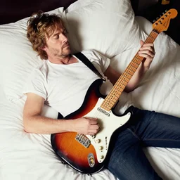annie leibovitz style color photoshoot of roy buchanan laying in bed, playing his telecaster
