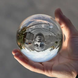 hand holding reflective glass ball, with face of mc escher reflected inside, in the style of escher