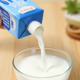 hose attached to opening on milk carton, pouring milk into bowl