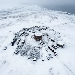 snowy region on coast of Iceland, abandoned mine and crates full of supplies buried in snow::2 aerial drone perspective, top down view ::1 sattelite image of snow from 250 meters height, some coal boxes and barrels are covered in snow, old mine remains :: 1 post apocalyptic, snowstorm ::5
