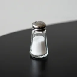 Salt shaker on a black table, minimalist photo