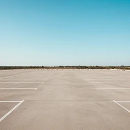 photo of a simple peaceful unnaturally expansive empty carpark with no cars