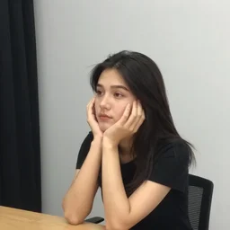 casual photograph of a woman sitting in a studio room pensively, with the poise and appearance of the ( ( ( ( ( ( ( ( 😺 ) ) ) ) ) ) ) ), taken in 2 0 1 9 with a digital camera, full color, head shot