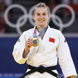 Emma Raducanu as a judo black belt, wearing a white gi, wearing a gold medal at the Olympics