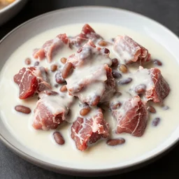 raw meat chunks in white gravy with beans,