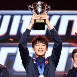 Close up photograph of a the happy smiling winner celebrating on stage holding the trophy high above their head, moment of victory as confetti flies through the air, video game tournament