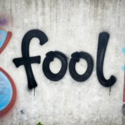 street graffiti bomb reading the word fool on a concrete wall