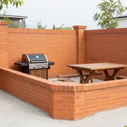 fenced in garden, orange brick fence, wood fired bbq and wooden table covered by trellis with vines, bright sunny day, blue skies, no clouds, artistic rendering 8k