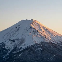 professional photo of a snow topped mountain lit by the sunset
