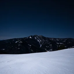 calming relaxing snowy mountain silhouetted against a dark starry night sky from a distance