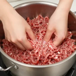 a pot full of raw mince being mixed up by hands, pov, 4 k