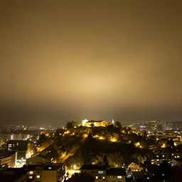looking up there is a city on a pit, night, in the ceiling there is fog, yellow light