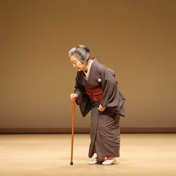 scene from a bunraku japanese puppet theater, a lone old woman walks bent over using a walking cane