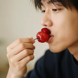 a photo of a person eating a cherry item from the pacman series