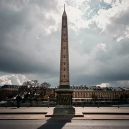 a obelisk on a bridge in france. overcast sky, grainy.