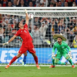 a soccer player scoring an epic goal against a goalkeeper wearing a sombrero
