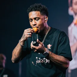 bladee eating kfc chicken on stage at the drain gang concert
