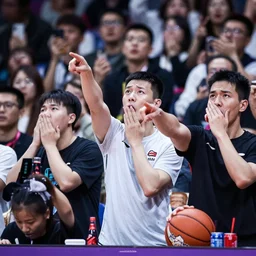audience at baseketball game looks upset, pointing, covering mouth