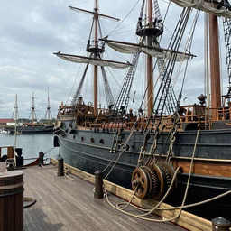a 1 7 th century steampunk ship building yard reflecting on the harbour, ropes and pulleys