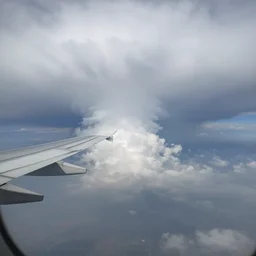 a wing view from 2 0 0 0 0 feet down to a giant storm cloud