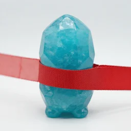 cyan crystal creature with a red cloth strip, product photo, 4K HD