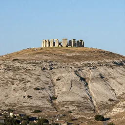 wide shot of a mediterranean mesa with a stone henge at the top of it