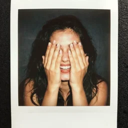 polaroid of laughing woman covering face, holiday