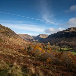 autumnal scottish valley view with background mountains and deep blue sky with cirrus clouds by tyler edlin