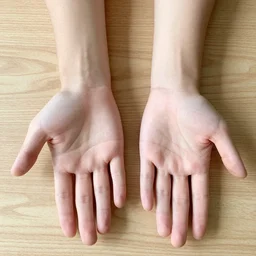 looking down at my left and right hands. my right hand is open with the palm facing down towards the table and my left hand is also open but the palm is facing up towards the camera