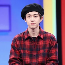 a thin guy with an overbite wearing a beret and a plaid shirt on a quiz tv show