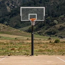 photograph of an isolated basketball backboard and rim on a dirt court in a scenic location, in the styles of cameron look, andrew bernstein, and ansel adams. intricate, hyperrealistic, monochrome hdr, accurate court