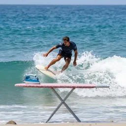 action picture of a man surfing on an ironing table