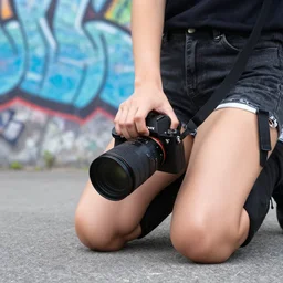 an urban close up photo, with graffiti in the background and a kneeling urban girl, camera sony a 7 c, lens sony 1 6 - 3 5 mm f / 2. 8, fish eye