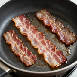 bacon being cooked fried forming a face