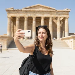 a female tourist taking a selfie in front of the ancient atlantis